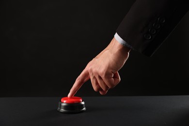 Photo of Man pressing button on black background, closeup. Space for text