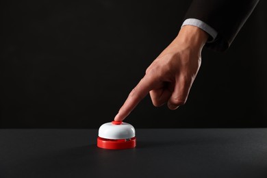 Photo of Man pressing button on black background, closeup. Space for text
