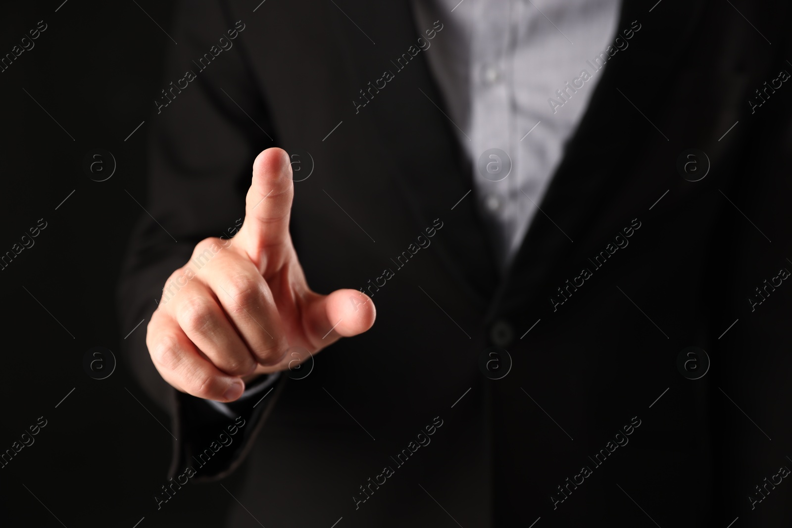 Photo of Man touching something on black background, closeup