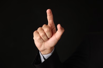 Photo of Man touching something on black background, closeup