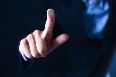 Photo of Man touching something on dark background, closeup