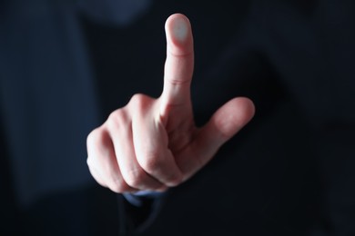 Photo of Man touching something on dark background, closeup