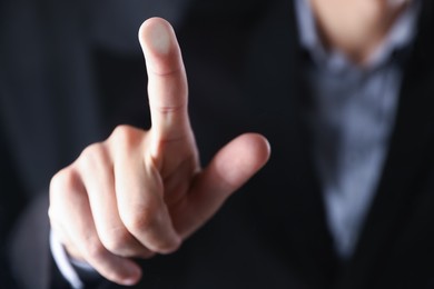 Photo of Man touching something on dark background, closeup