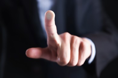 Photo of Man touching something on dark background, closeup