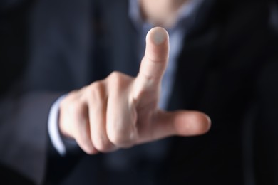 Photo of Man touching something on dark background, closeup