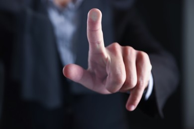 Photo of Man touching something on dark background, closeup