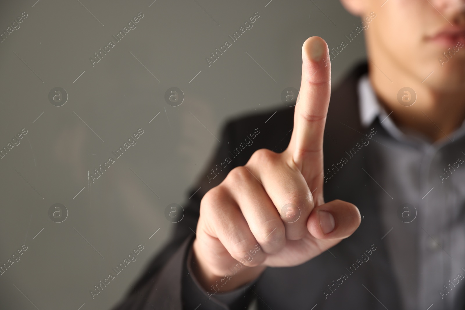 Photo of Man touching something on grey background, closeup. Space for text