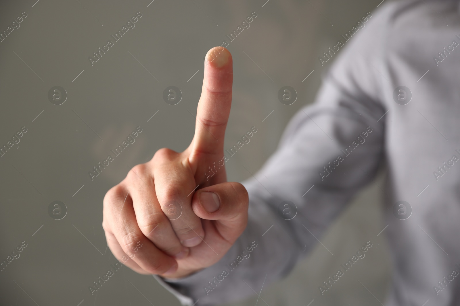 Photo of Man touching something on grey background, closeup