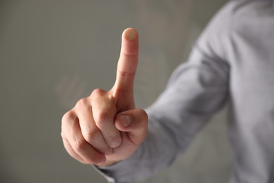 Photo of Man touching something on grey background, closeup