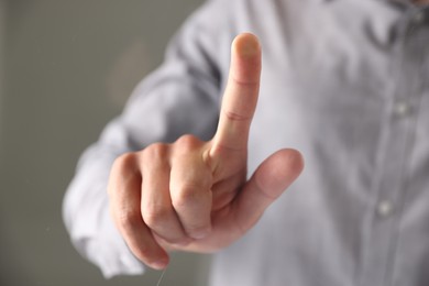 Photo of Man touching something on grey background, closeup