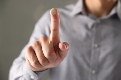 Photo of Man touching something on grey background, closeup