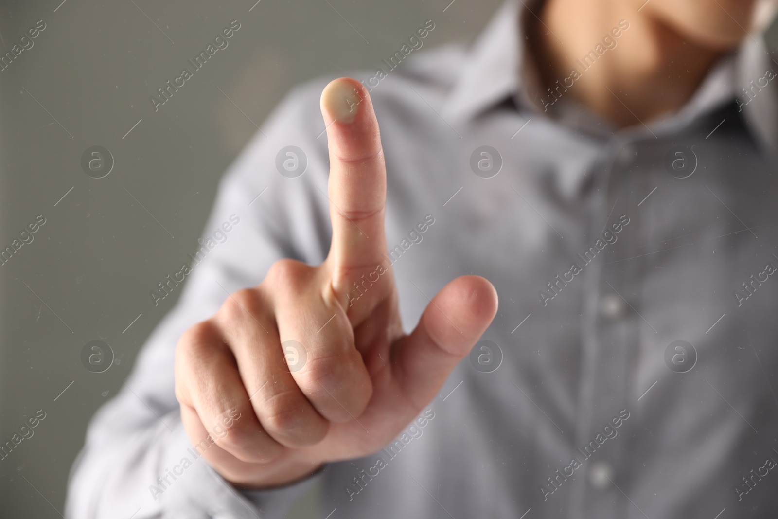Photo of Man touching something on grey background, closeup