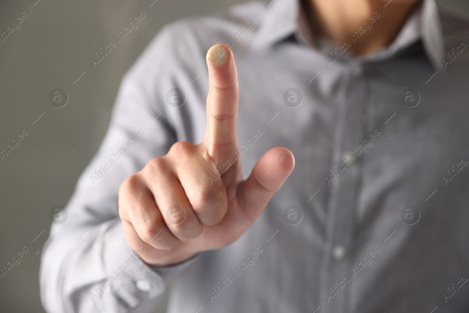 Photo of Man touching something on grey background, closeup