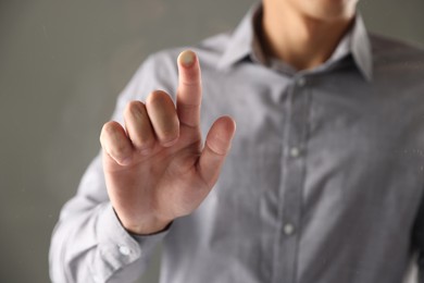 Photo of Man touching something on grey background, closeup