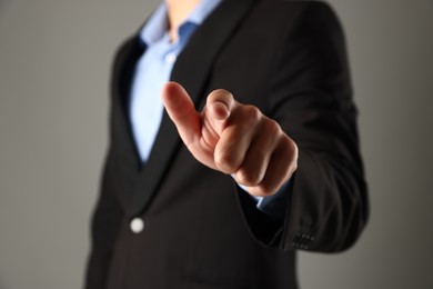 Photo of Man touching something on grey background, closeup