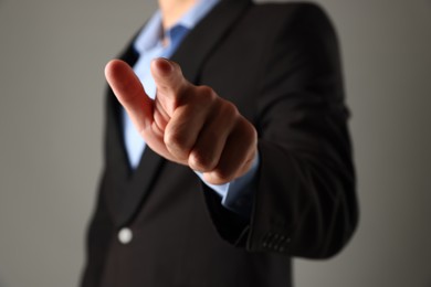 Photo of Man touching something on grey background, closeup