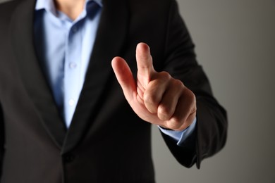 Photo of Man touching something on grey background, closeup
