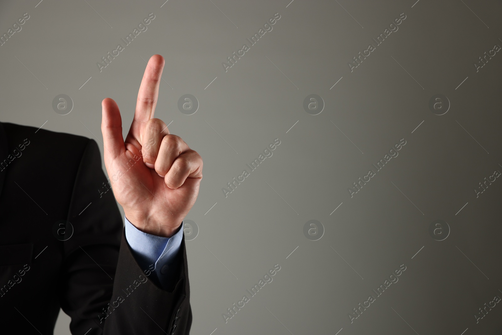 Photo of Man touching something on grey background, closeup. Space for text