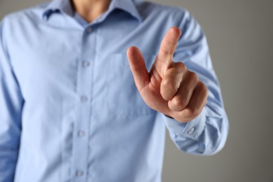Photo of Man touching something on grey background, closeup