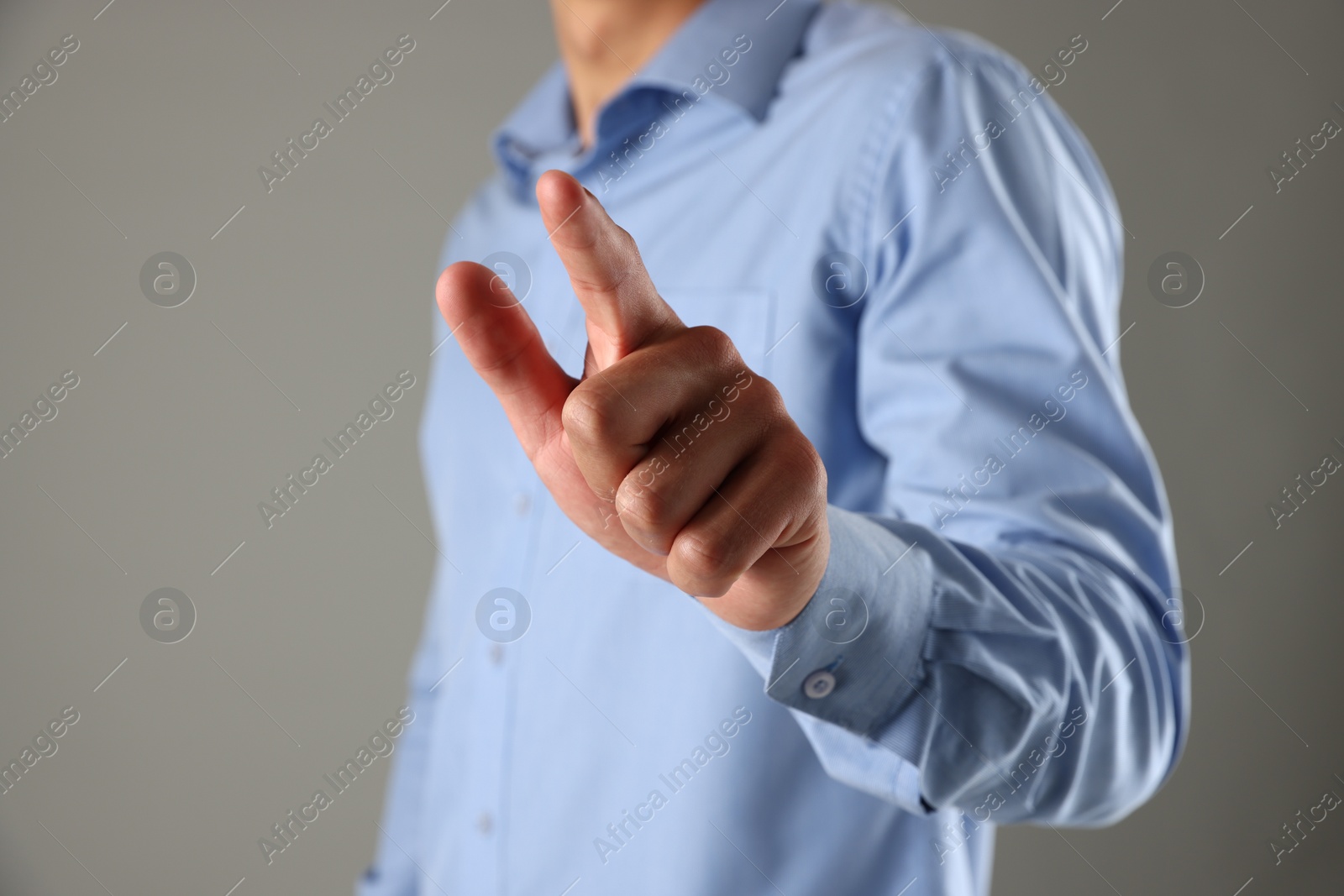 Photo of Man touching something on grey background, closeup