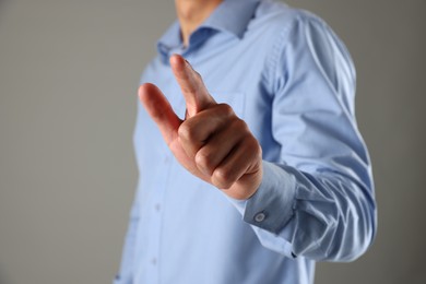 Photo of Man touching something on grey background, closeup