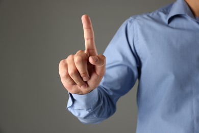 Photo of Man touching something on grey background, closeup