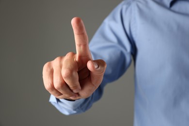 Photo of Man touching something on grey background, closeup