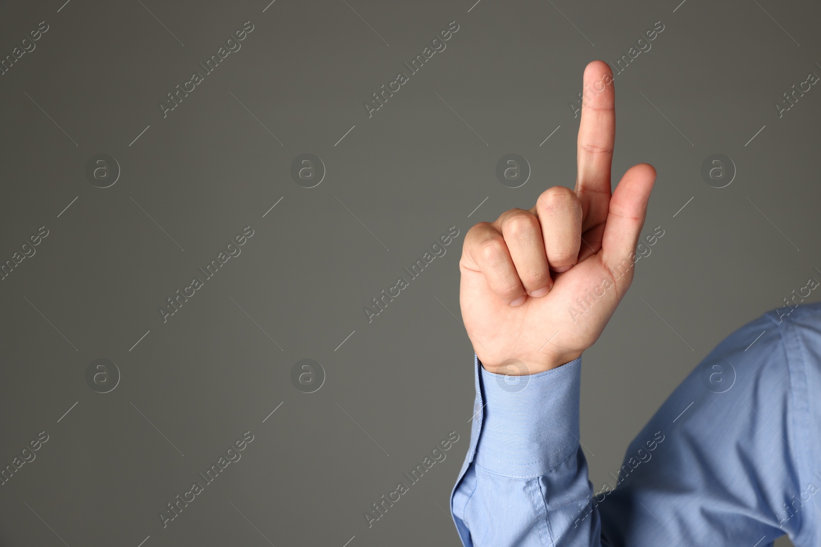Photo of Man touching something on grey background, closeup. Space for text