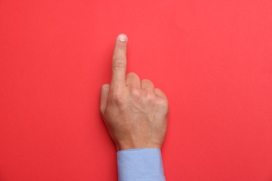 Photo of Man touching something on red background, top view