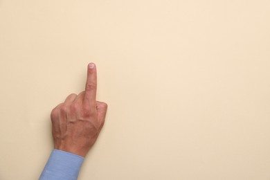 Photo of Man touching something on beige background, top view. Space for text