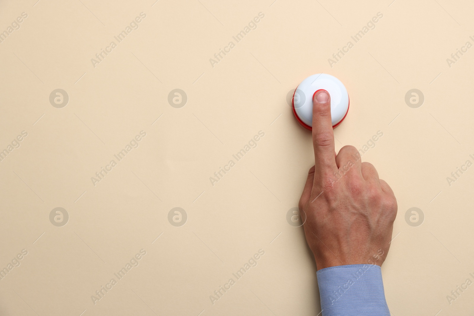 Man pressing button on beige background, top view. Space for text Photo of Man pressing button on beige background, top view. Space for text