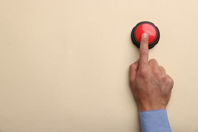 Photo of Man pressing button on beige background, top view. Space for text