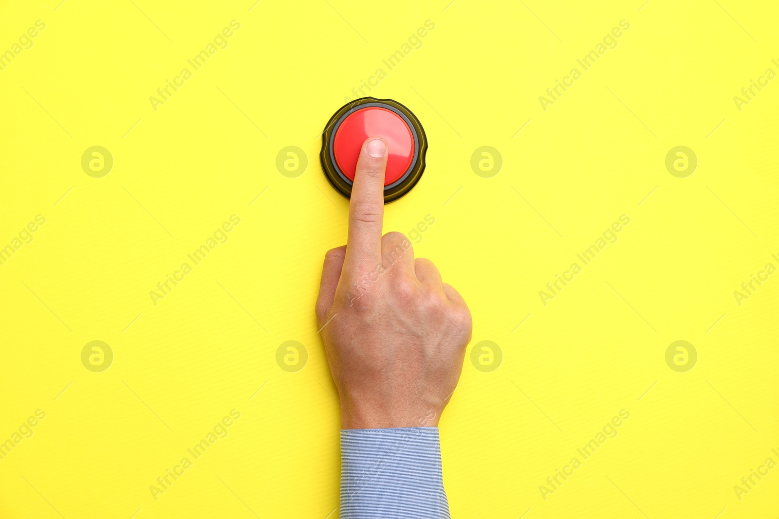 Man pressing button on yellow background, top view Photo of Man pressing button on yellow background, top view