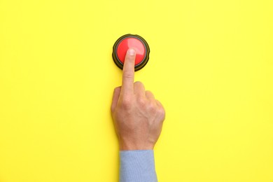 Photo of Man pressing button on yellow background, top view