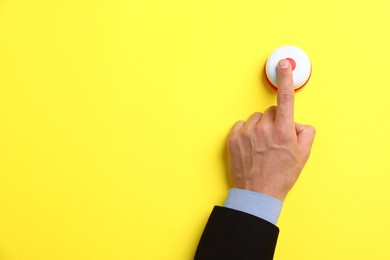 Photo of Man pressing button on yellow background, top view. Space for text