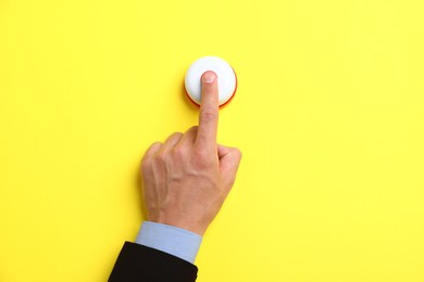Photo of Man pressing button on yellow background, top view. Space for text