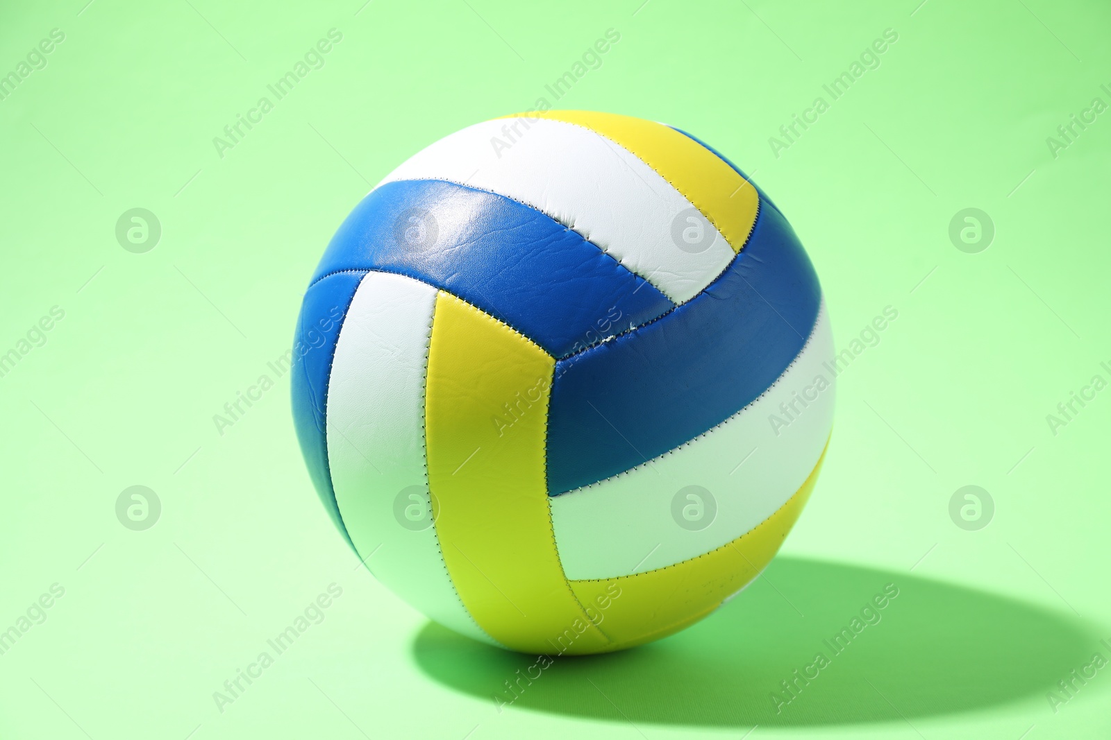 Photo of Colorful volleyball ball on light green background
