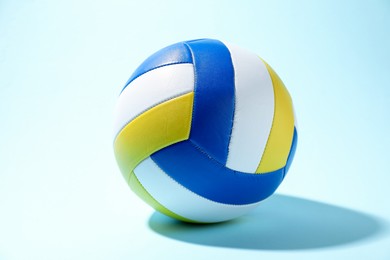 Photo of One colorful volleyball ball on light blue background