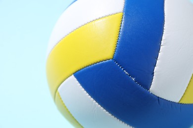 Photo of Colorful volleyball ball on light blue background, closeup