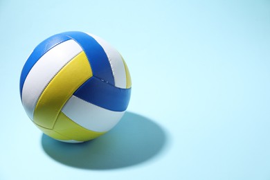 Photo of Colorful volleyball ball on light blue background. Space for text