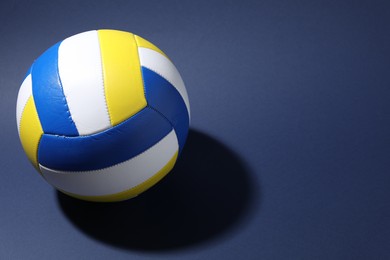 Photo of Colorful volleyball ball on blue background. Space for text