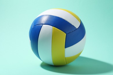 Photo of One colorful volleyball ball on turquoise background