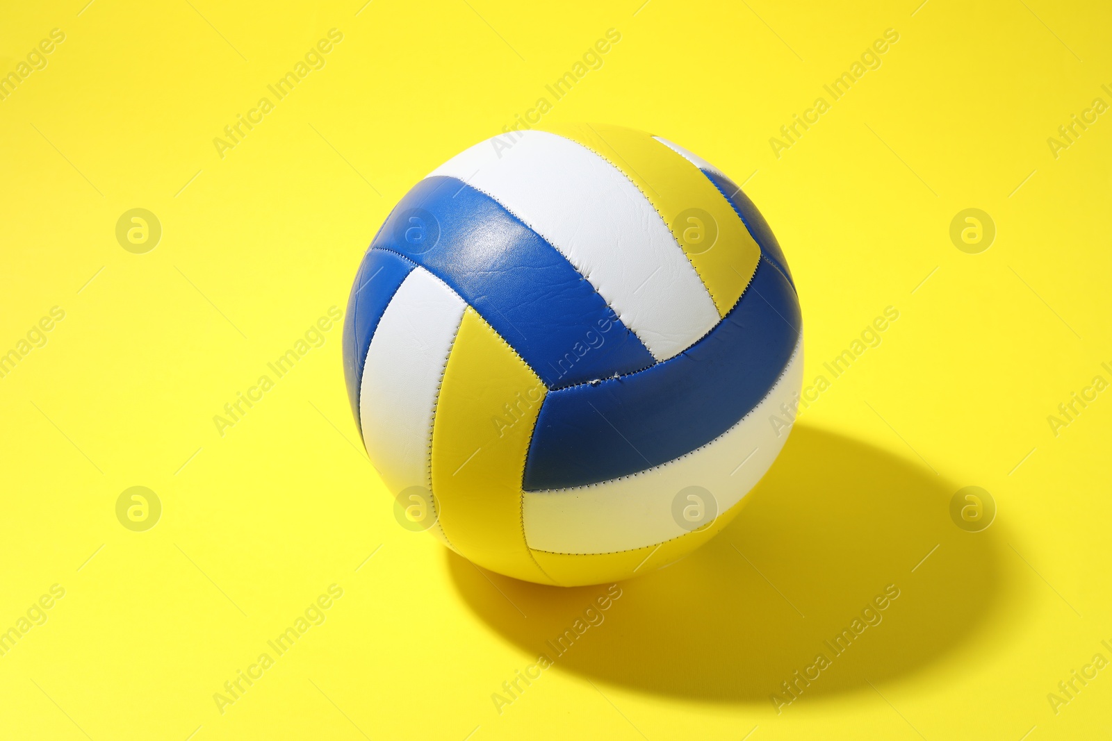 Photo of One colorful volleyball ball on yellow background