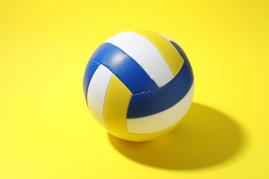 Photo of One colorful volleyball ball on yellow background