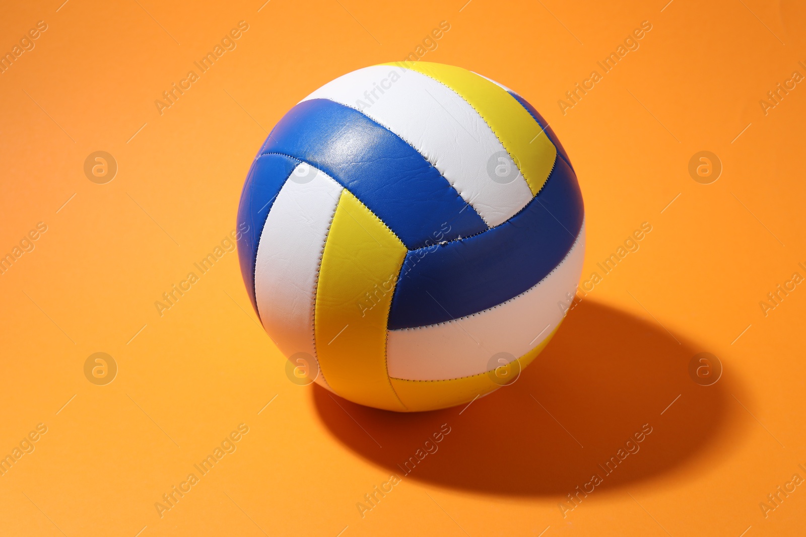Photo of One colorful volleyball ball on orange background