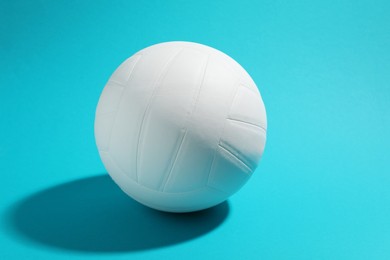 Photo of White volleyball ball on light blue background