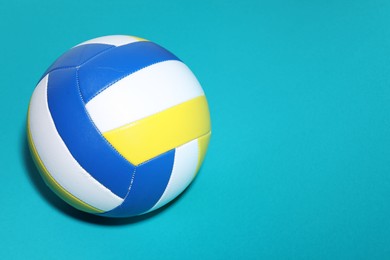 Photo of Colorful volleyball ball on light blue background, above view. Space for text