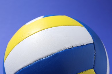 Photo of Colorful volleyball ball on blue background, closeup