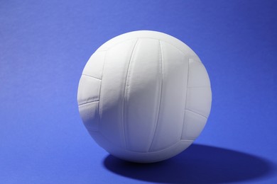 Photo of One white volleyball ball on blue background