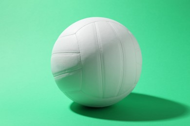 Photo of One white volleyball ball on green background